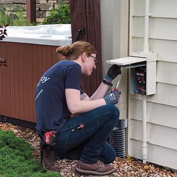 McElroy Electric electrician examines outdoor electrical connections for a hot tub.