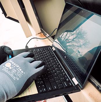 McElroy Electric technician uses a laptop to run diagnostic checks on an industrial-quality Kohler Generator.