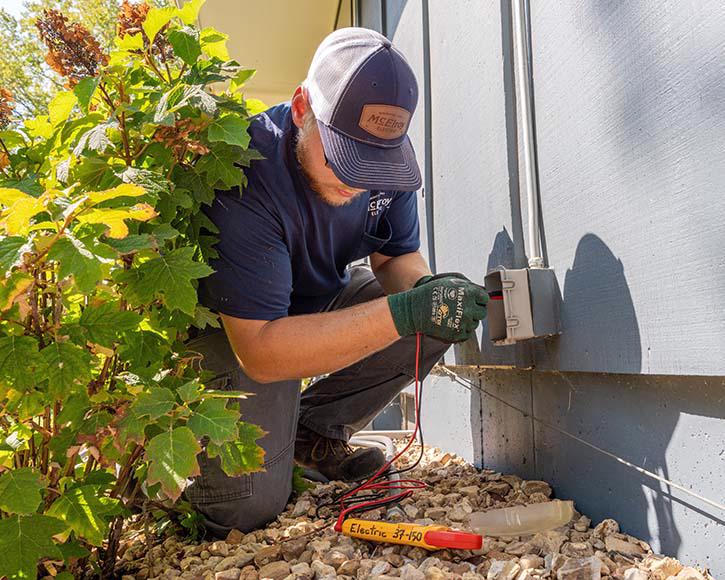 A McElroy Electric electrician tests an outdoor electrical outlet.