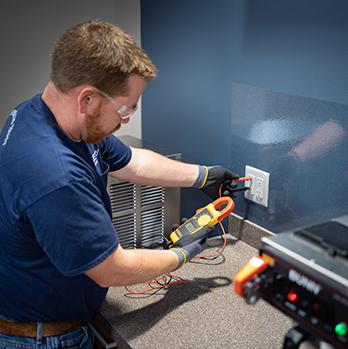 McElroy Electric technician runs diagnostics on office place wall outlets.