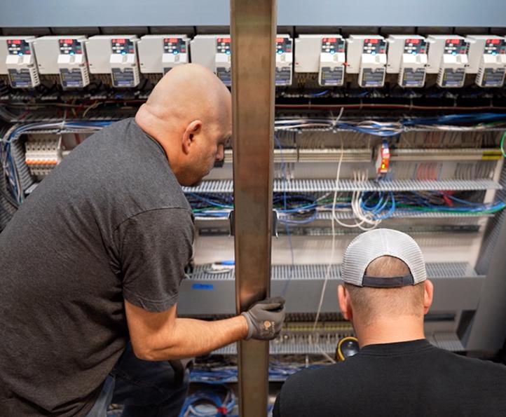 McElroy Electric technicians working in control panel.