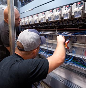 McElroy Electric technicians working in control panel. 