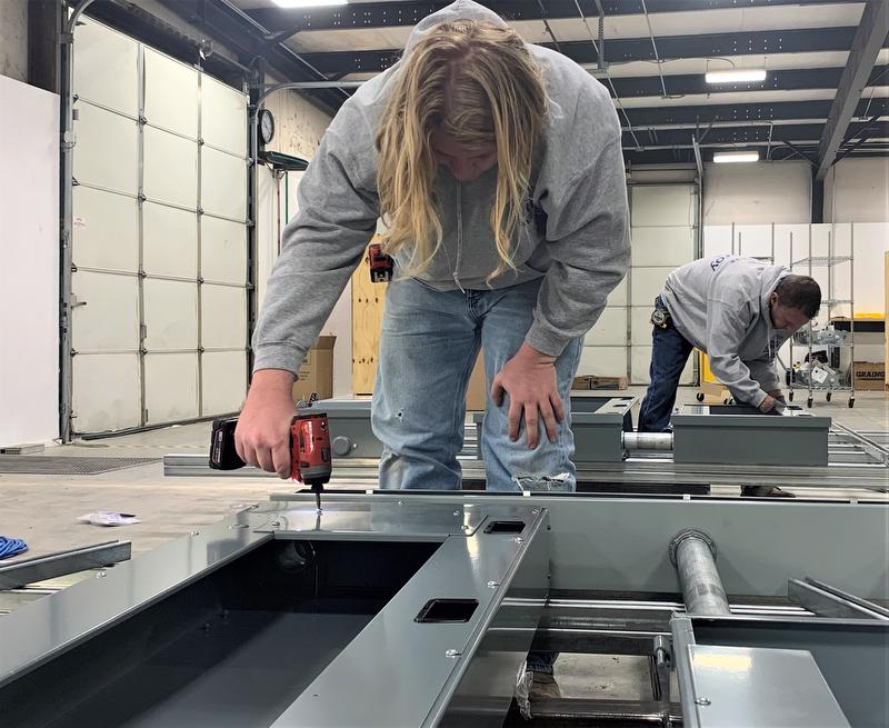 Two certified electricians build sub-panel assemblies in the McElroy Electric prefabrication shop.