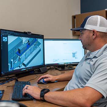 Project manager revieiwng construction plans on a computer screen.
