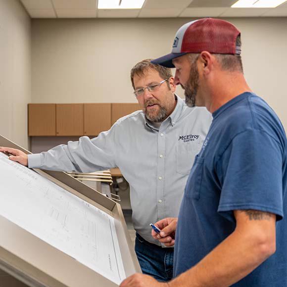 McElroy Electric leaders discuss an electrical construction project.