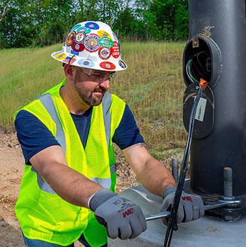 McElroy Electric electrician tightens down a new light pole.