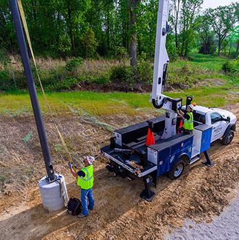 McElroy Electric team installs a new light pole using our bucket-truck jib.