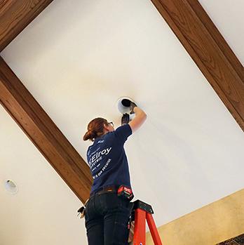 McElroy Electric electrician does repairs on high, vaulted-ceiling lighting fixture.